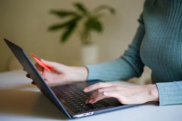 Una mujer trabaja desde un computador portátil.