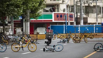 Um entregador de comida navega entre bicicletas compartilhadas formando uma barricada temporária durante um bloqueio.Fonte: Bloomberg