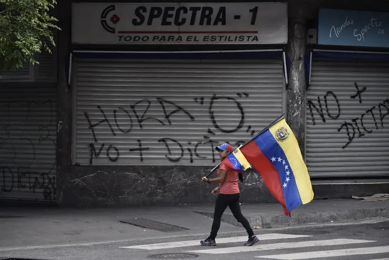 Una mujer lleva una bandera de Venezuela durante una protesta antigubernamental en el municipio Chacao, en Caracas, Venezuela, el 20 de julio de 2017. dfd