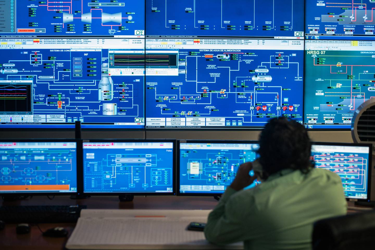 Un empleado habla por teléfono mientras monitorea operaciones en el centro del control de una central eléctrica de la Comision Federal de Electricidad (CFE).