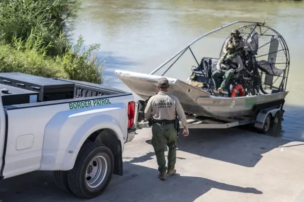 US Border Patrol agents prepare to go into the Rio Grande in Eagle Pass, Texas.