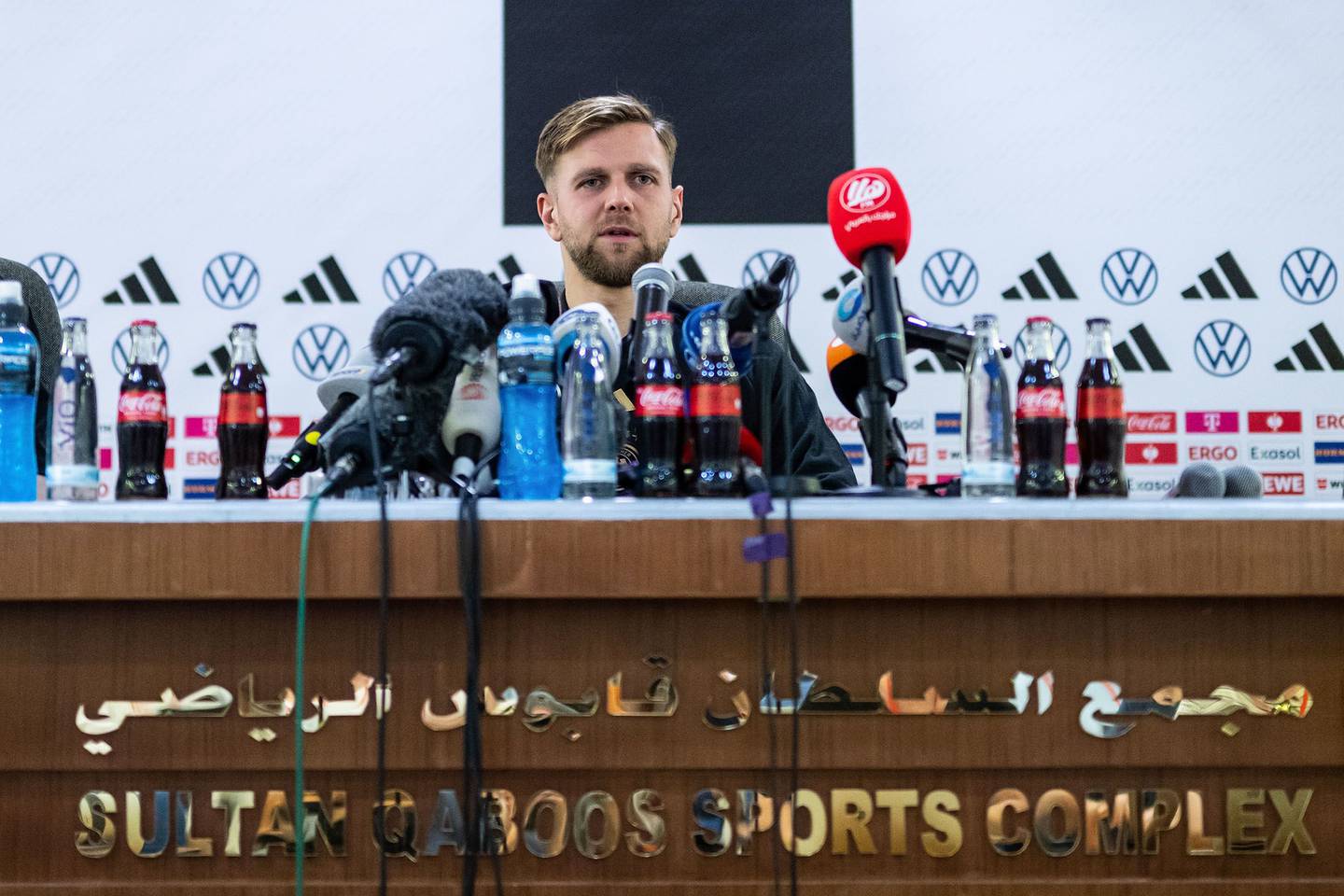 Bottles of Coca-Cola line the desk of a German team pre-tournament news conference in Muscat, Oman, on Nov. 15. dfd