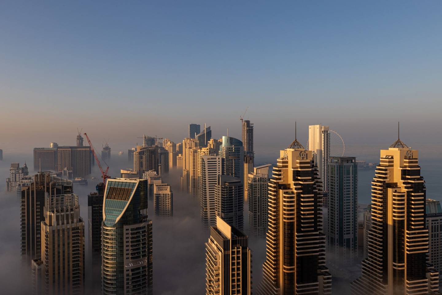 La niebla matutina rodea rascacielos residenciales y comerciales en el distrito de Marina Dubai, en Dubai, Emiratos Árabes Unidos.
