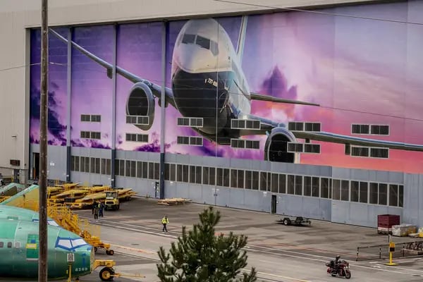 Un trabajador camina bajo un mural de un avión 737-800 de Boeing Co. fuera de la planta de fabricación de la compañía en Renton, Washington, Estados Unidos, el lunes 21 de marzo de 2022. Foto: Bloomberg