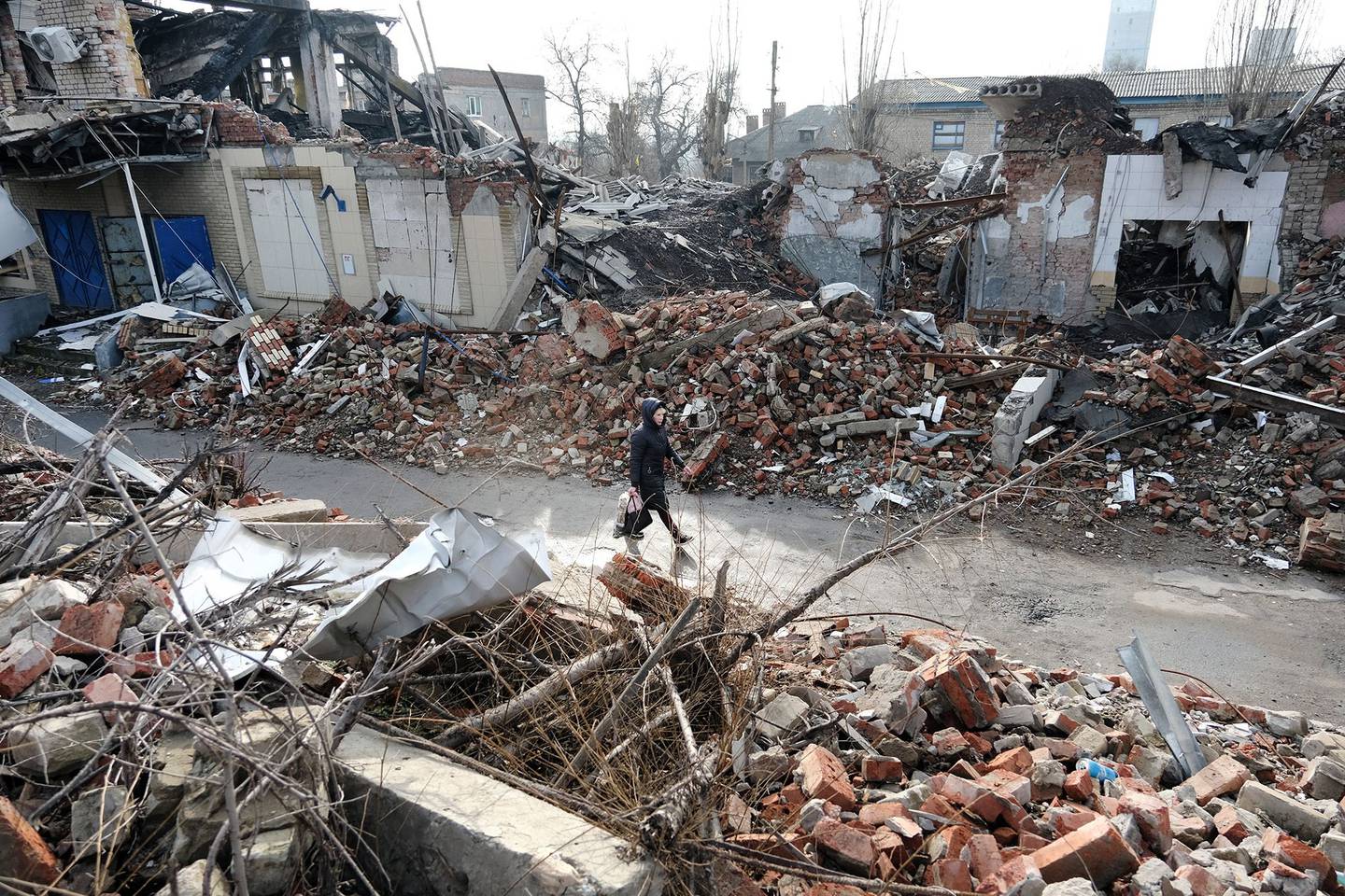 Una mujer camina junto a edificios destruidos a 32 kilómetros al oeste del frente de los combates el 20 de enero de 2023 en la región de Donetsk, Ucrania.