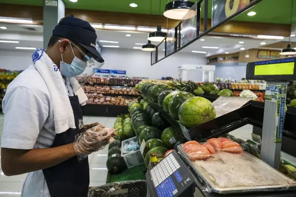 An employee wearing a protective mask and a face shield arranges products inside the SM Supermarket at the SM Pampanga mall in Manila, the Philippines, on Thursday, Dec. 17, 2020. The Philippine government lowered its outlook for the economy this year, now expecting a contraction of 8.5% to 9.5% as the country battles the second-worst virus outbreak in Southeast Asia. Photographer: Vejay Villafranca/Bloomberg