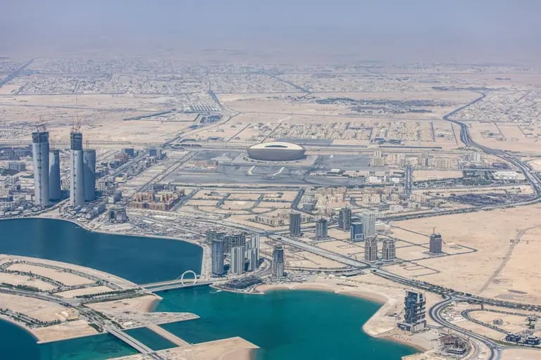 El estadio de fútbol de Lusail, sede de la Copa Mundial de la FIFA 2022, más allá de los rascacielos residenciales y comerciales de Doha, Qatar, el lunes 20 de junio de 2022. Fotógrafo: Christopher Pike/Bloombergdfd