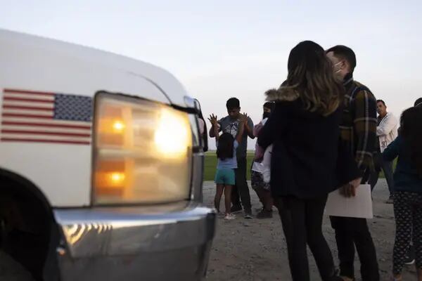 Migrantes en busca de asilo esperan a ser procesados por agentes de la Patrulla Fronteriza de Estados Unidos después de cruzar la frontera entre México y Estados Unidos en Yuma, Arizona,