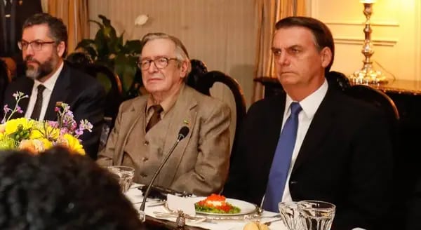 Olavo de Carvalho no auge da influência, sentado entre Bolsonaro e Ernesto Araújo, em jantar na embaixada brasileira em Washington em 2019