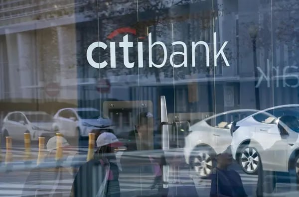 Personas camiana reflejadas al pasar por una sucursal de Citibank en Washington, DC, US,  el sábado, 18 de noviembre, 2023.