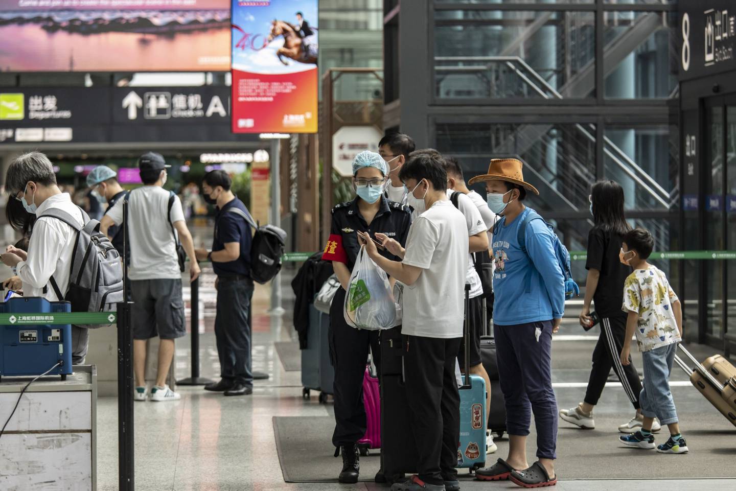 Viajeros presentan sus códigos sanitarios para su inspección en el Aeropuerto Internacional de Hongqiao en Shanghai, China.