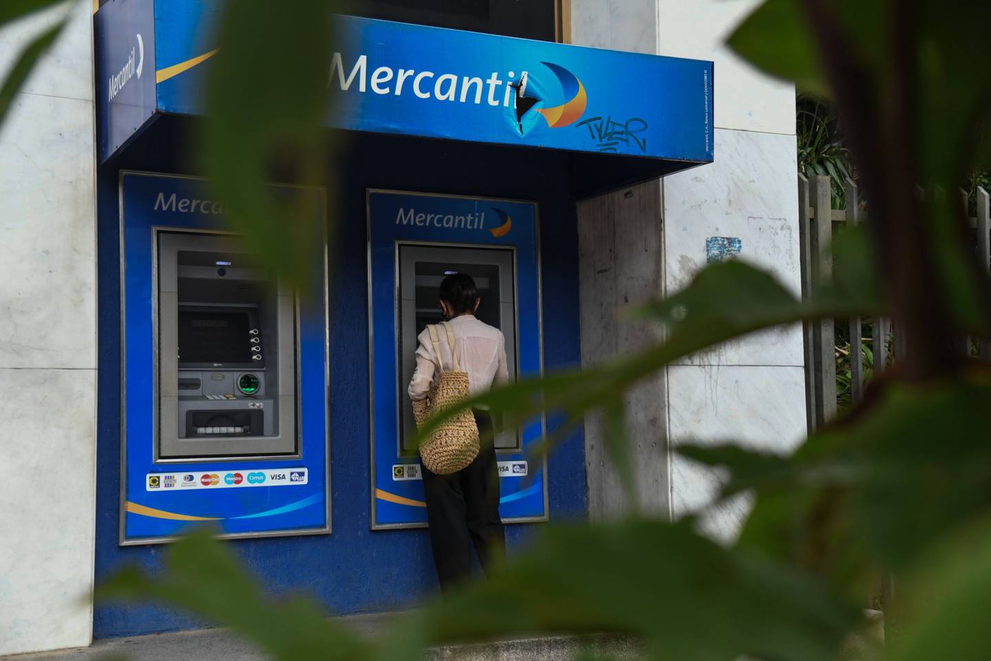 Un cliente usa un cajero automático del Mercantil Bank en Caracas.