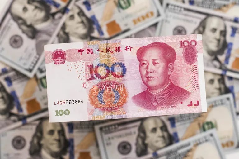 Un billete chino de cien yuanes sobre una pila de billetes de cien dólares estadounidenses en esta fotografía arreglada tomada en Hong Kong, China, el lunes 20 de julio de 2015.dfd