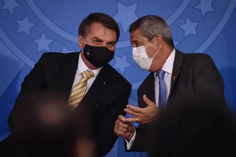 Jair Bolsonaro, presidente de Brasil, a la izquierda, y Walter Braga Netto, jefe de gabinete de Brasil, llevan una máscara protectora mientras hablan durante un evento en el Palacio de Planalto en Brasilia, Brasil, el viernes 15 de mayo de 2020.dfd