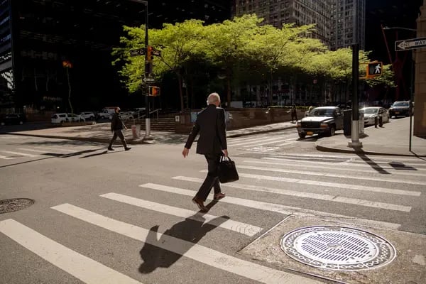 Un peatón con un maletín cruza una calle del distrito financiero de Nueva York, Estados Unidos, el miércoles 12 de mayo de 2021. Fotógrafo: Amir Hamja/Bloomberg