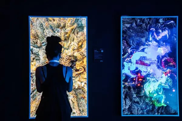 Visitors look at digital artworks by Refik Anadol showcasing digital and NFT art in Hong Kong.