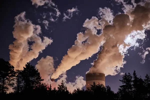 Las luces iluminan el vapor que sale de las torres de refrigeración y las chimeneas de la central eléctrica de carbón de Belchatow, operada por PGE SA, antes del amanecer en Belchatow, Polonia.