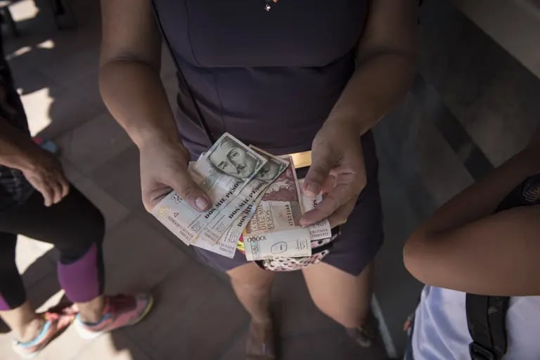 A woman receives Pesos in exchange for Bolivars after the re-opening of the borders in Cucuta, Colombia on Tuesday, Dec. 20, 2016. President Nicolas Maduro agreed to gradually re-open borders with Colombia after closing them last week in response to what officials called contraband "mafias." Photographer: Carlos Becerra/Bloombergdfd