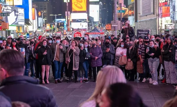 Los turistas observan a un artista callejero en Times Square, en Nueva York, el 16 de diciembre.