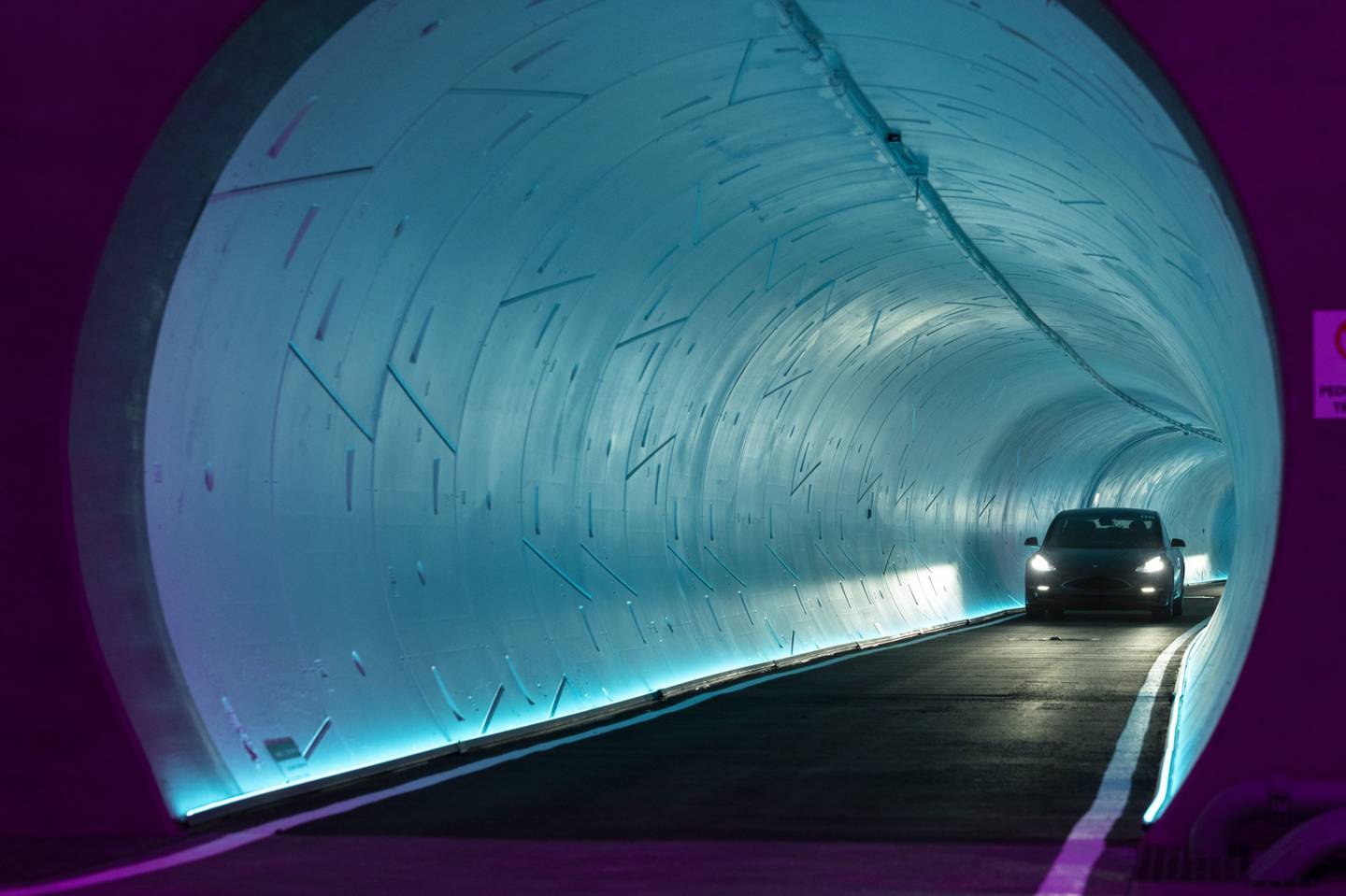 A Tesla Inc. electric vehicle passes through an underground tunnel during a tour of the Boring Co. Convention Center Loop in Las Vegas, Nevada, U.S., on Friday, April 9, 2021. Once operational, Tesla vehicles capable of carrying up to 16 passengers will shuttle through the tunnel, turning a 1.5 mile walk on the surface into a trip that takes a couple of minutes.dfd