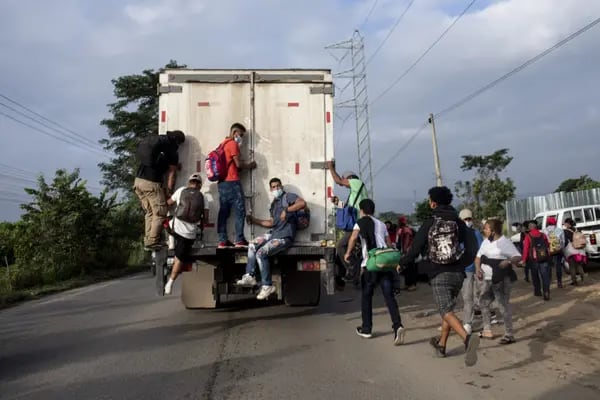 Migrantes hondureños suben a un camión mientras viajan a la frontera con Guatemala cerca de La Entrada, Honduras, el viernes 15 de enero de 2021.