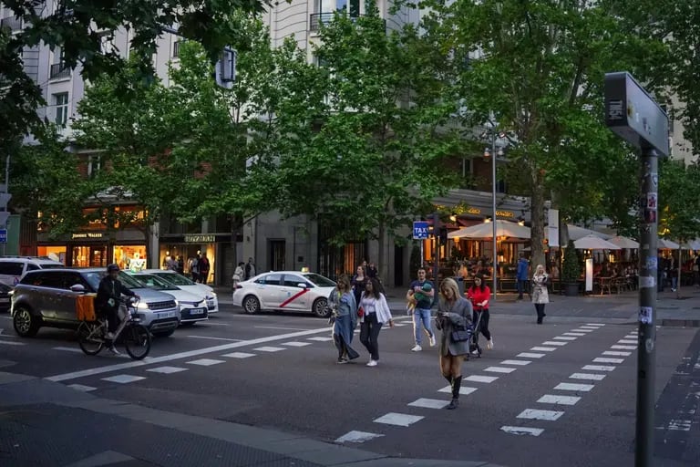 Pedestrians cross a street lined with upmarket stores in the Salamanca district of Madrid, Spain, on Saturday, May 27, 2023. A flood of funds from well-heeled Latin Americans is changing the face of Madrid: driving property prices soaring and creating a sizzling hot high-end dining scene.dfd