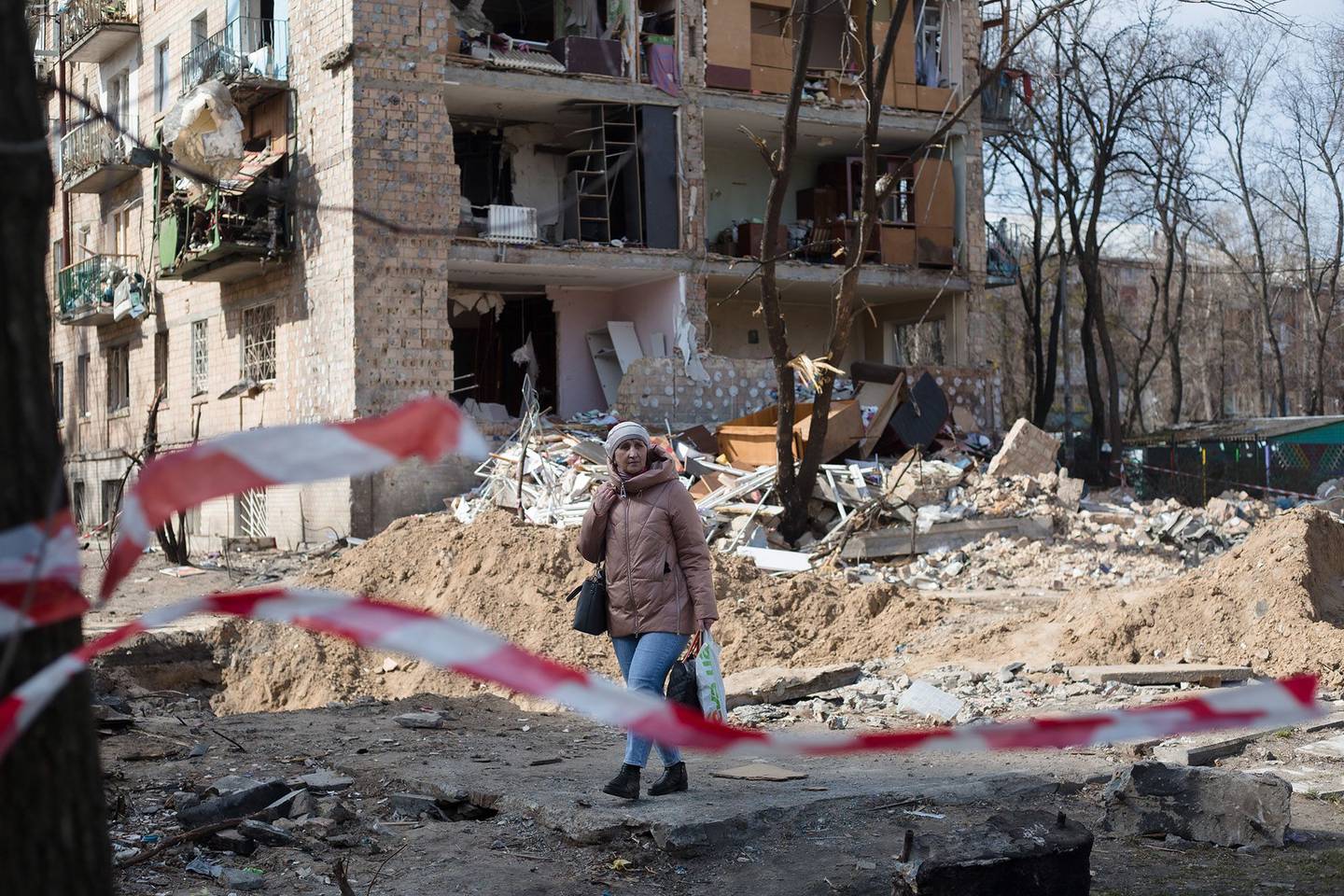A woman walks past a residential area which was destroyed as a result of a rocket strike two weeks ago on March 28, 2022 in Kyiv, Ukraine.