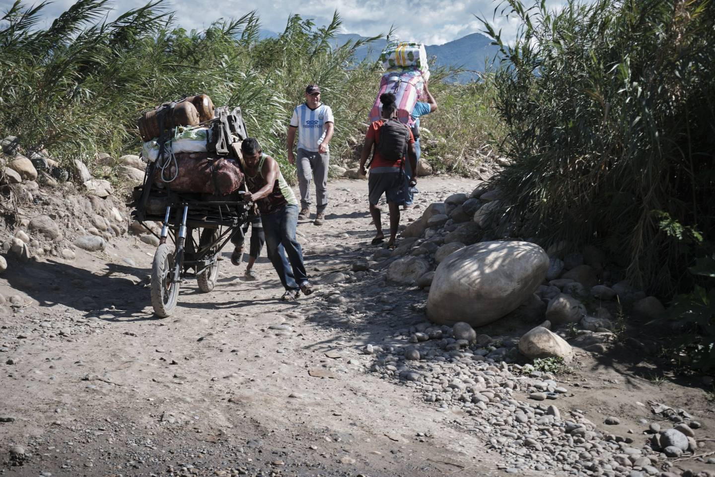 Los residentes que llevan mercancías caminan a lo largo de un sendero cerca del puente internacional Francisco de Paula Santander mientras se reabre cerca de la frontera con Venezuela en Cúcuta, Colombia, el lunes 8 de agosto de 2022.dfd