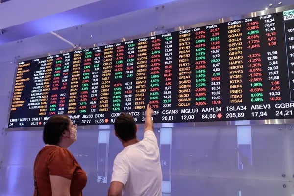 A visitor points to an electronic board displaying stock activity at the Brasil Bolsa Balcao (B3) stock exchange in Sao Paulo, Brazil, on Monday, Nov. 8, 2021.