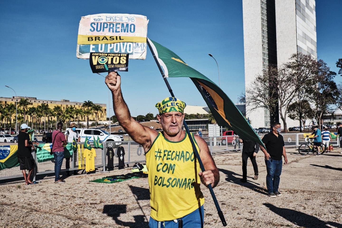 Un partidario de Bolsonaro ondea una bandera de Brasil durante un desfile militar.dfd
