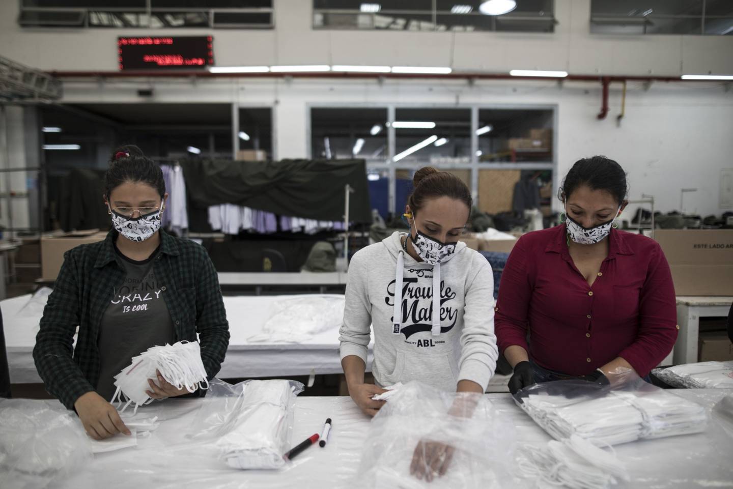 Los trabajadores empaquetan máscaras protectoras en la fábrica de ropa de la Policía Nacional en Bogotá, Colombia, el sábado 28 de marzo de 2020.