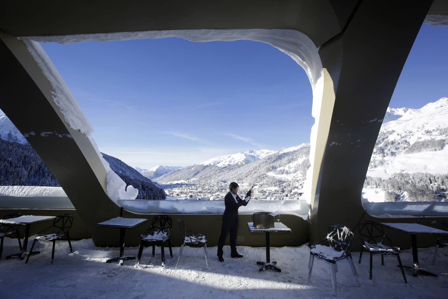 An employee checks a bottle of champagne on the bar terrace of the InterContinental Hotel, Davos 1n 2016.dfd