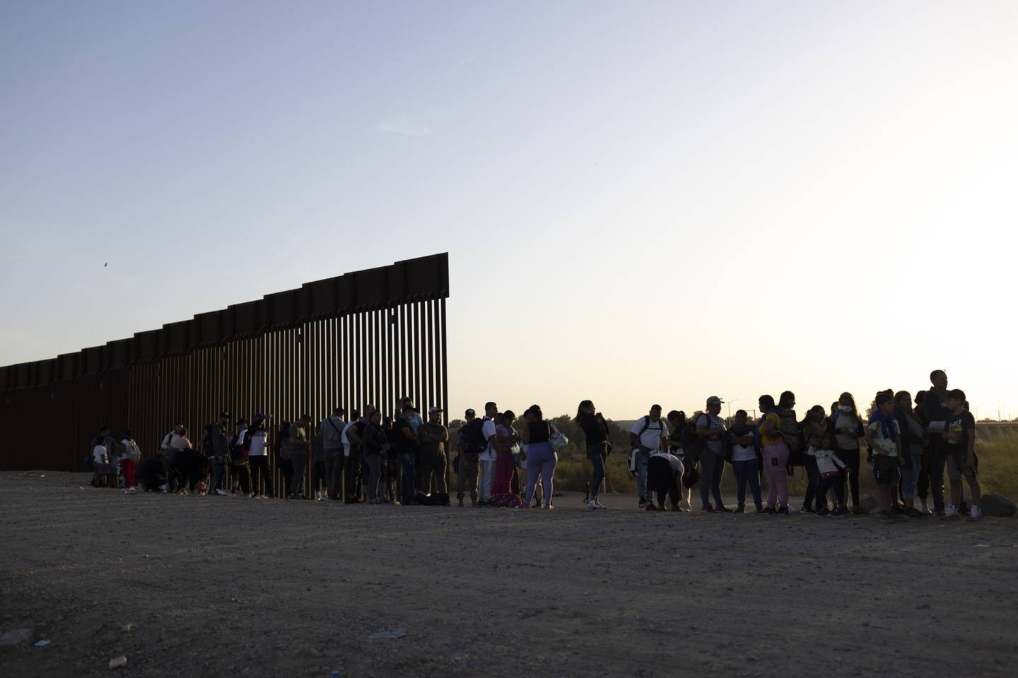 Migrantes en busca de asilo esperan a ser procesados por agentes de la Patrulla Fronteriza de Estados Unidos tras cruzar la frontera entre México y Estados Unidos en Yuma, Arizona, Estados Unidos.