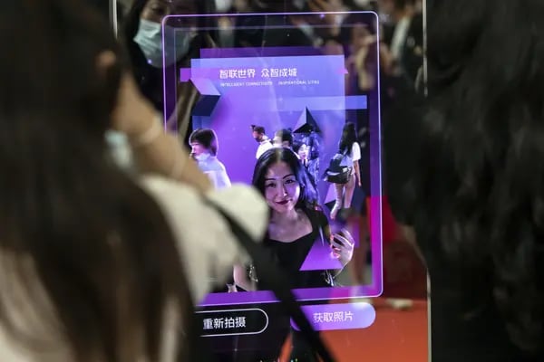 An attendee scans her face at a facial recognition entry gate at the World Artificial Intelligence Conference (WAIC) in Shanghai, China.