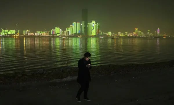 Un visitante mira un smartphone a orillas del río Yangtze por la noche, en Wuhan, provincia de Hubei, China.