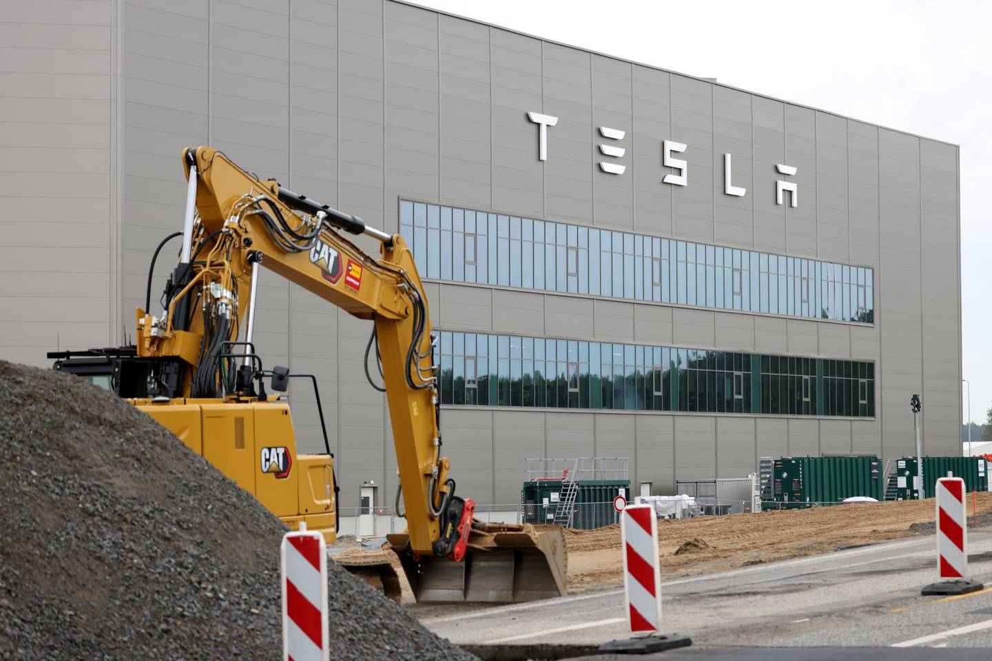 Una excavadora trabaja junto a una gigafactory de la empresa fabricante de vehículos eléctricos Tesla en Alemania