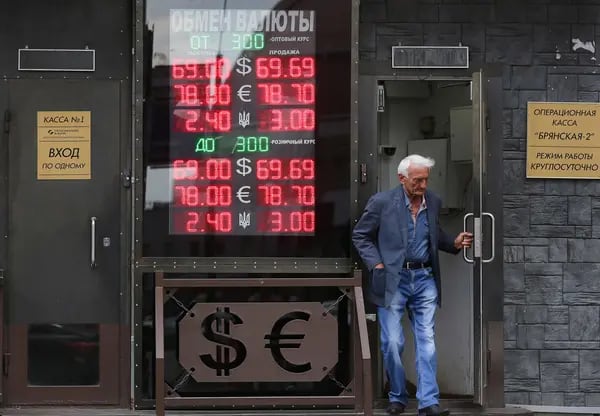 A customer exits a foreign currency exchange bureau advertising euro, dollar and ruble rates in Moscow.