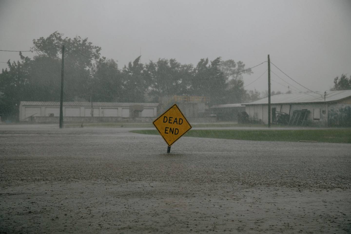 Una señal de tránsito en medio de agua de inundación tras un huracán en Luisiana.