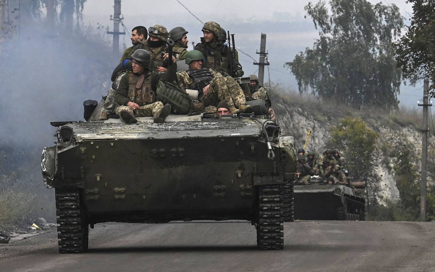 Soldados ucranianos sentados sobre vehículos blindados