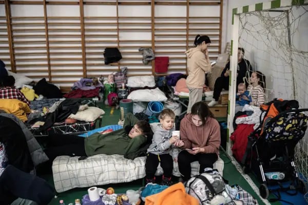 Ucranianos desplazados y sus hijos descansan en un refugio temporal en Tiszabecs, Hungría, el lunes 28 de febrero de 2022.