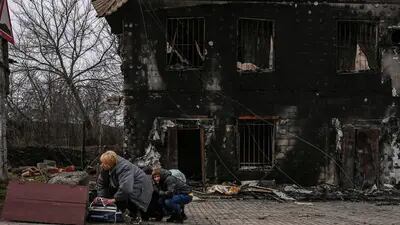 Moradores se protegem do bombardeio russo em Bucha, a noroeste de Kiev, em 4 de março.Fotógrafo: Aris Messinis/AFP/Getty Images