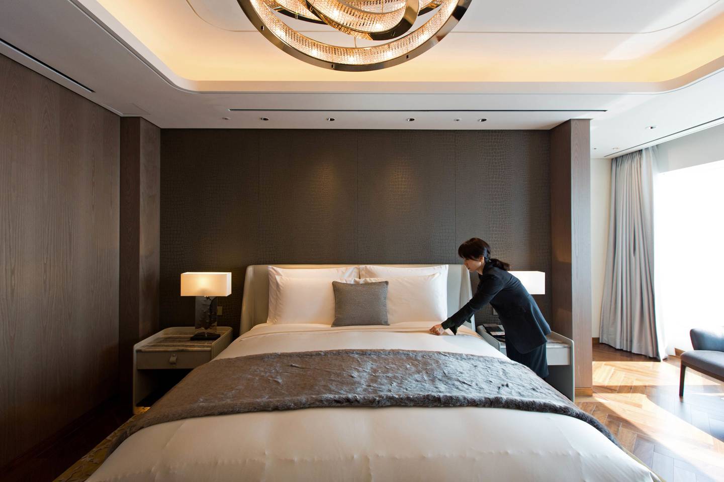 Un empleado hace una cama dentro de una habitación Royal Suite en el hotel Lotte Co. dentro del edificio Lotte Corp. World Tower en Seúl, Corea del Sur.