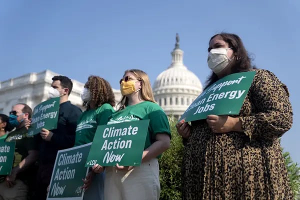 Los activistas sostienen carteles de "Acción climática ahora" durante una conferencia de prensa fuera del Capitolio de EE.UU., en Washington.