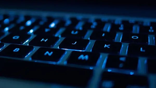 Un hacker informático escribiendo en el teclado.