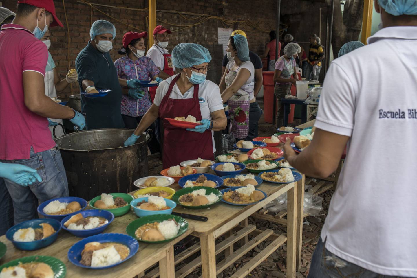 Los voluntarios sirven comida en Casa de Paso, una iglesia benéfica que ofrece comidas diarias y asistencia médica básica, en Cúcuta, Colombia, el miércoles 20 de septiembre de 2017.