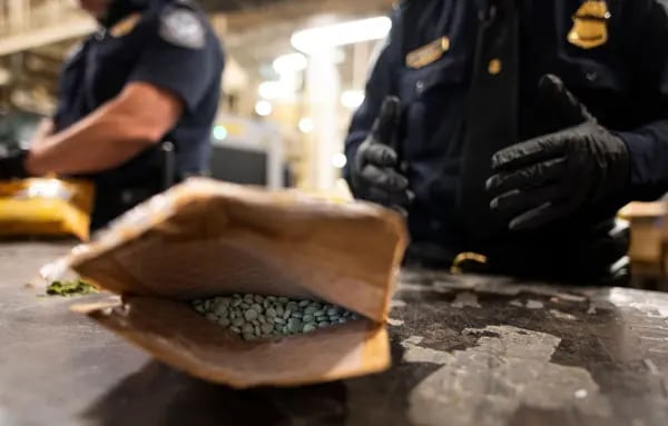 An officer from the US Customs and Border Protection, Trade and Cargo Division finds Oxycodone pills in a parcel at John F. Kennedy Airport's US Postal Service facility.