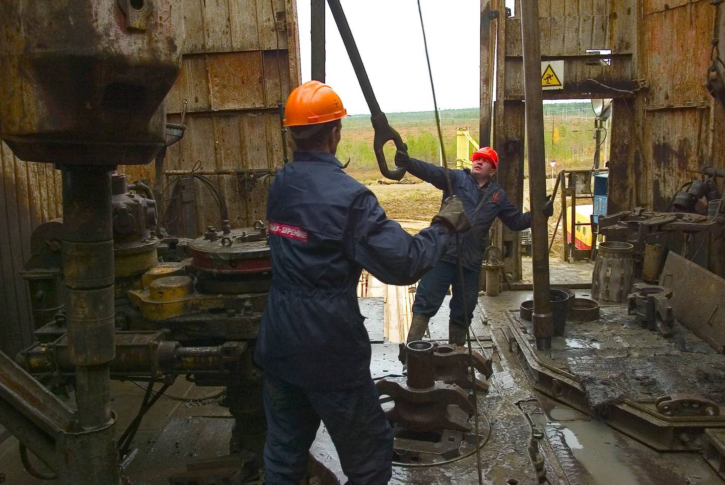 Trabajadores supervisan un equipo de perforación en una torre de perforación en el yacimiento petrolífero Ozernoje, propiedad de Lukoil, en los Urales, Rusia.