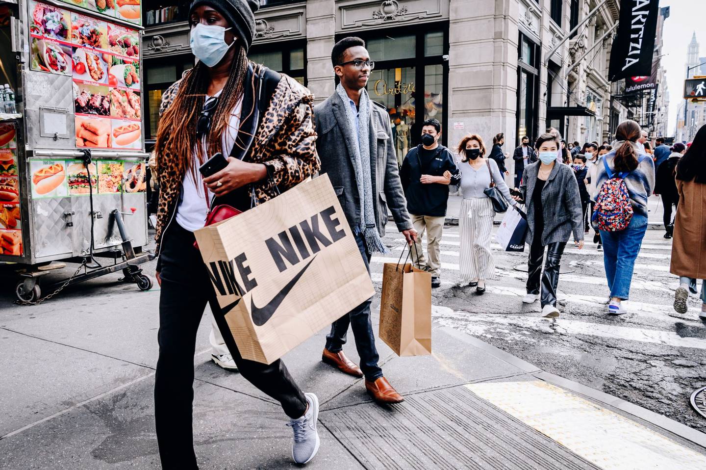 Peatones con bolsas de compras de Nike Inc. en el barrio del SoHo de Nueva York.