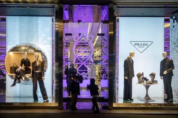Unos niños miran el escaparate de la tienda de Prada en la Quinta Avenida de Nueva York, Estados Unidos, el jueves 2 de diciembre de 2021.