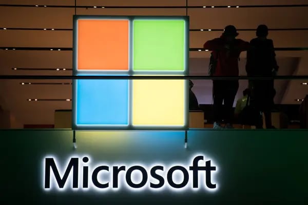 Los clientes se sitúan cerca del logotipo de Microsoft Corp. durante el evento de lanzamiento mundial de la videoconsola Microsoft Corp. Xbox One X en Nueva York, Estados Unidos, el lunes 6 de noviembre de 2017.  Fotógrafo: Mark Kauzlarich/Bloomberg